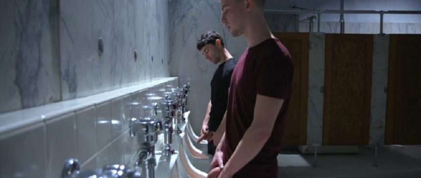 Gay men pissing at urinals